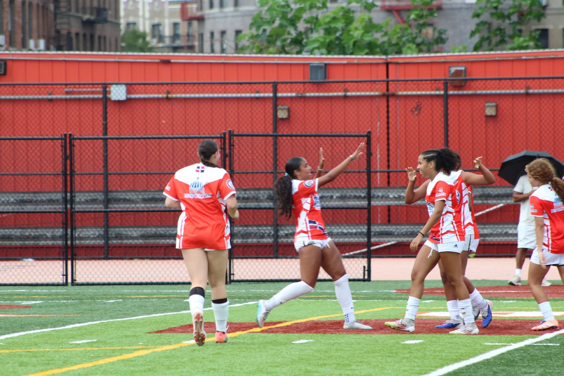 New Jersey players run together with arms raised after scoring.