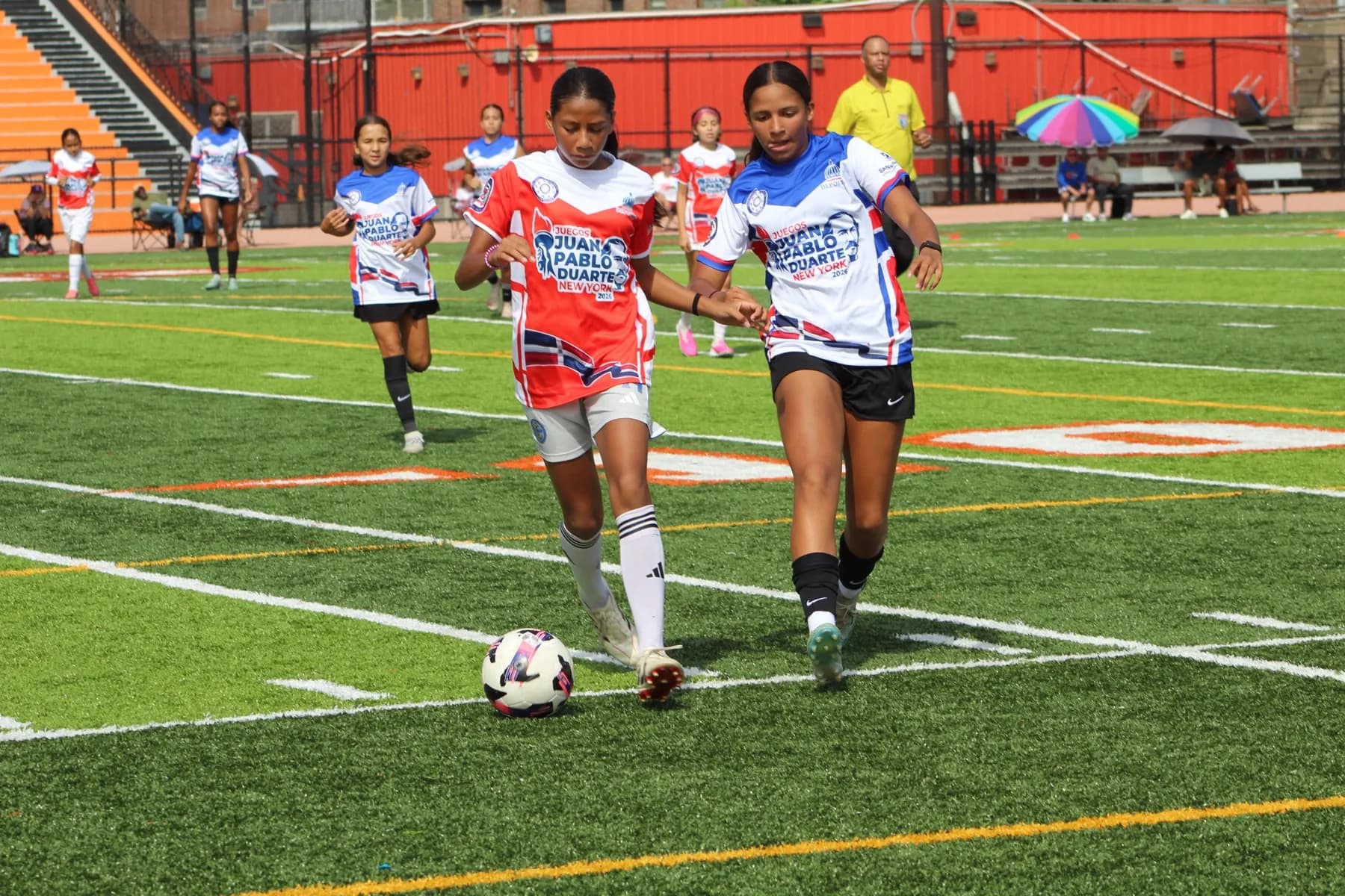 Two New York players drive forward together with the ball between them.