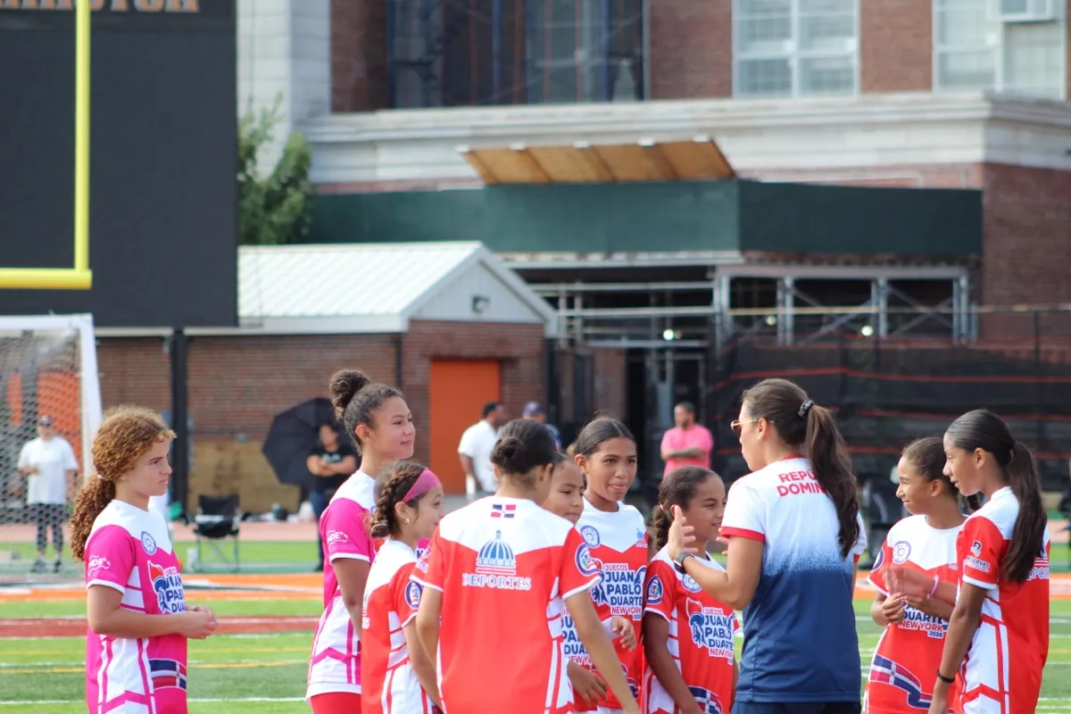 Players gather around their guest coach on the sideline.
