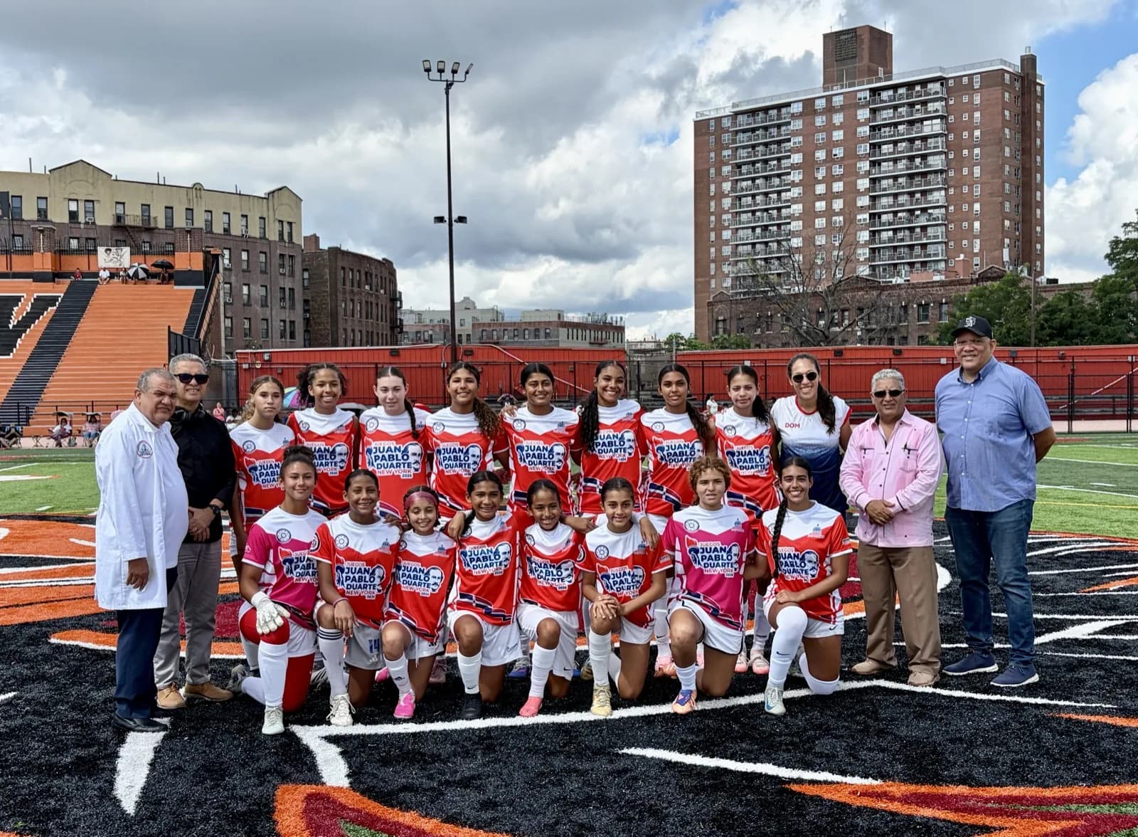 The New Jersey squad in red kits with their guest coach and Games officials at the George Washington turf field.